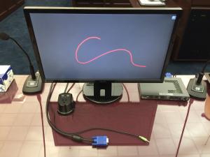 Picture of a laptop at a counsel table with the VGA cable plugged into the evidence presentation system