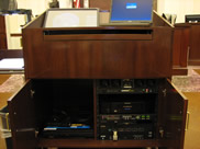 Podium with open doors showing the DVD/VCR and Blu-Ray Players